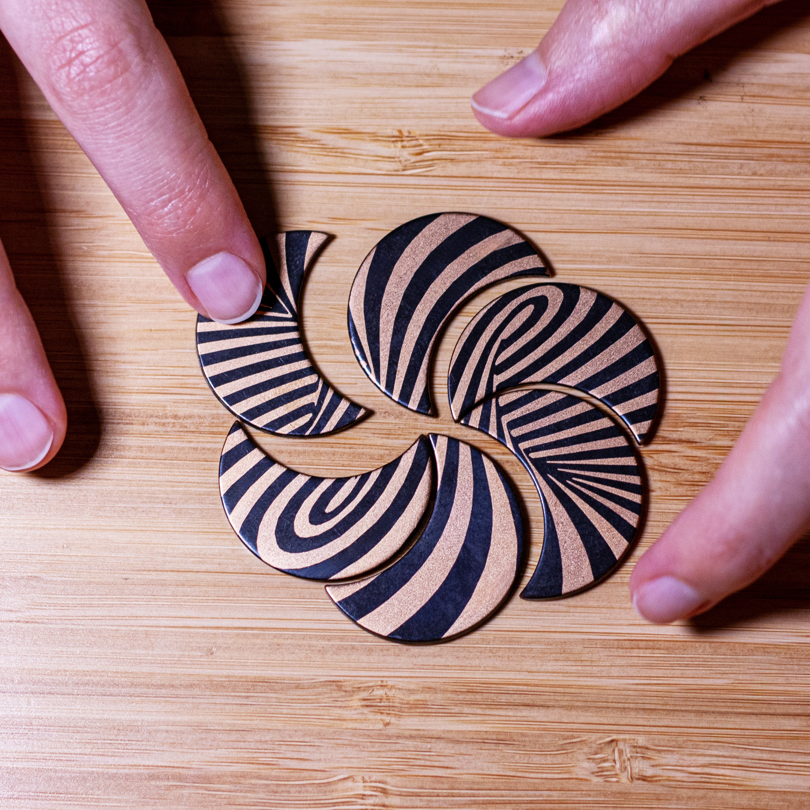 Hands putting bronze optical illusion together