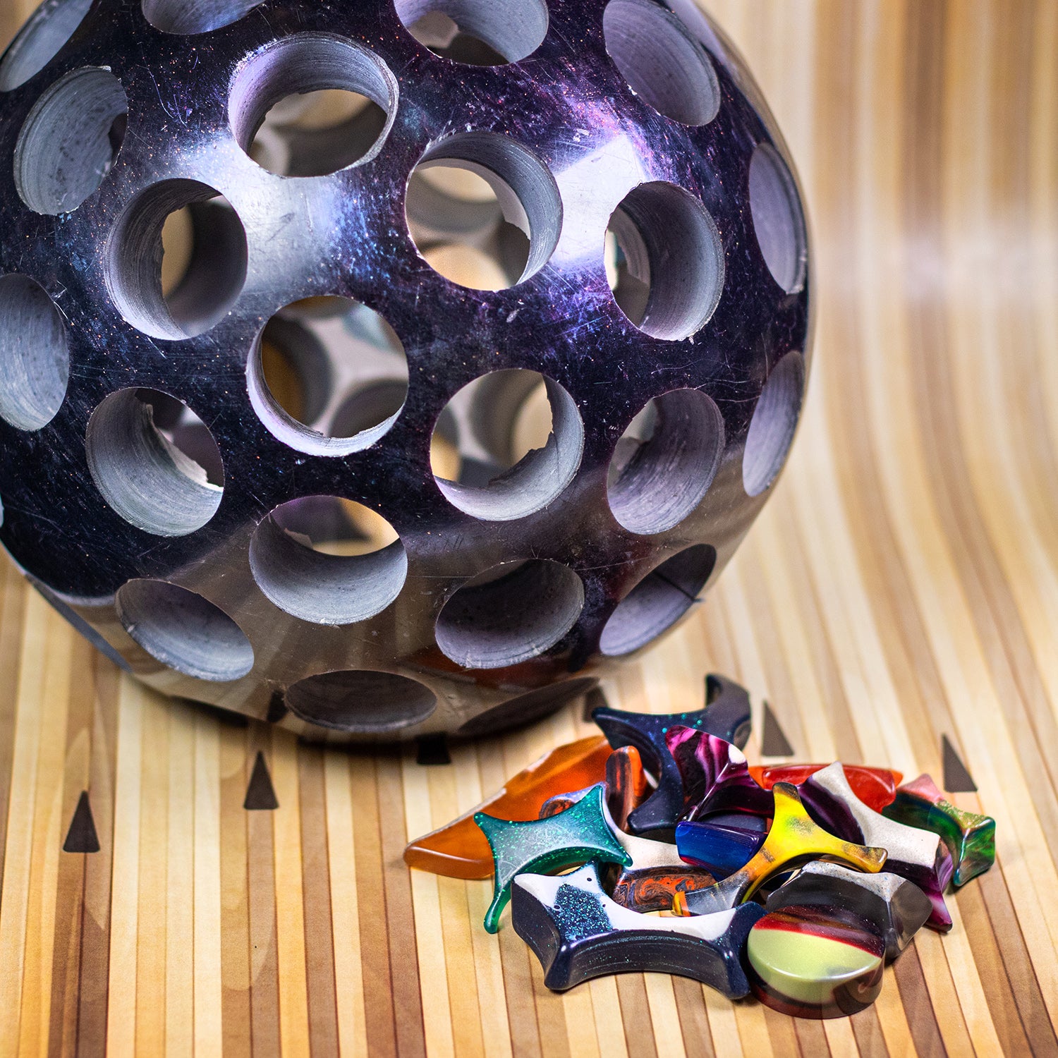 Small pile of Bowlerite Fidget Chunks next to a drilled out bowling ball