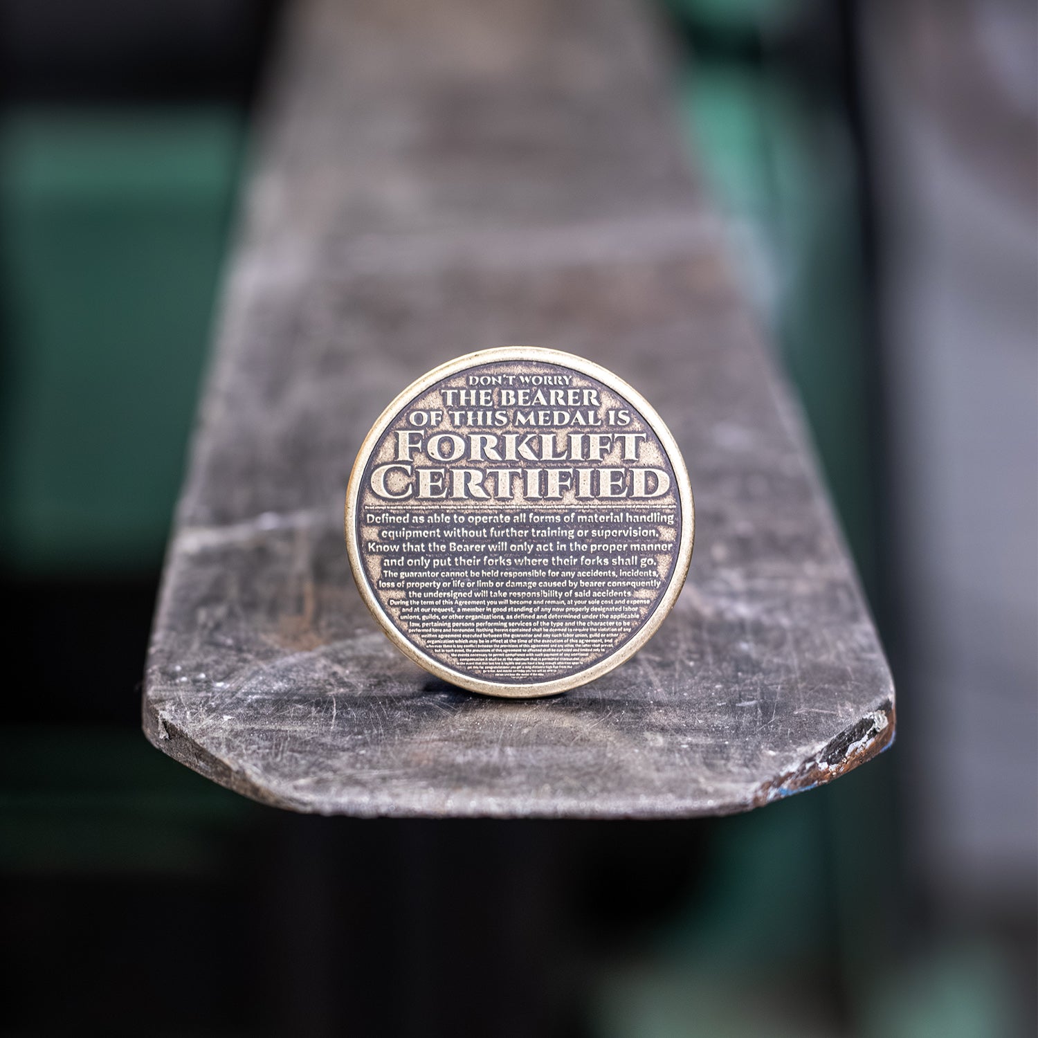 Brass coin depicting text, Don't Worry, the Bearer of this Medal is Forklift Certified'