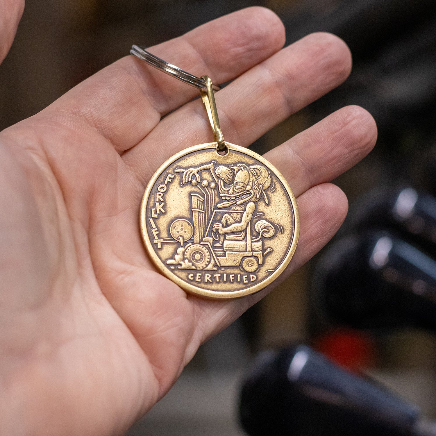 Hand holding brass Forklift Certified keyring