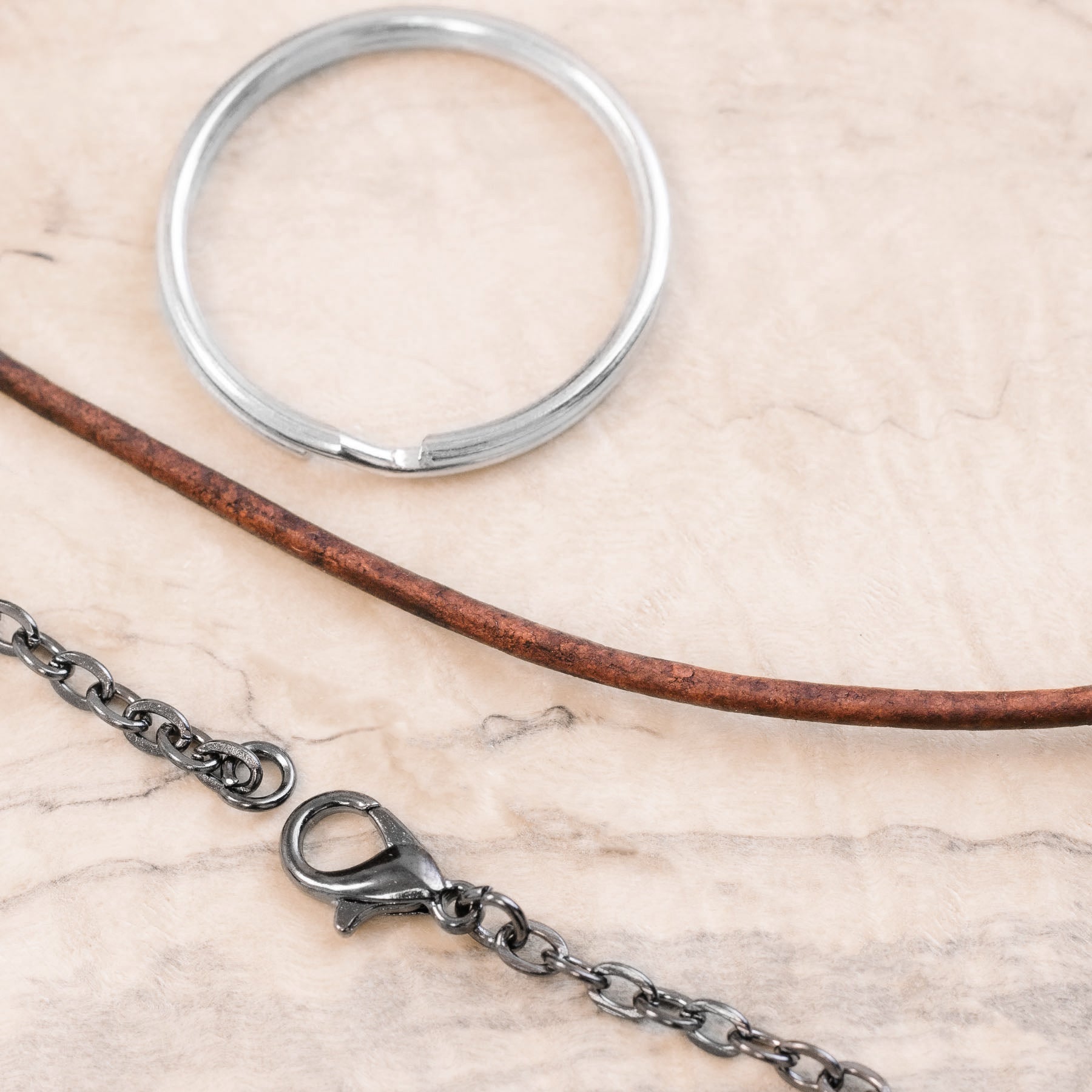 Display of keyring, leather cord, and black chain