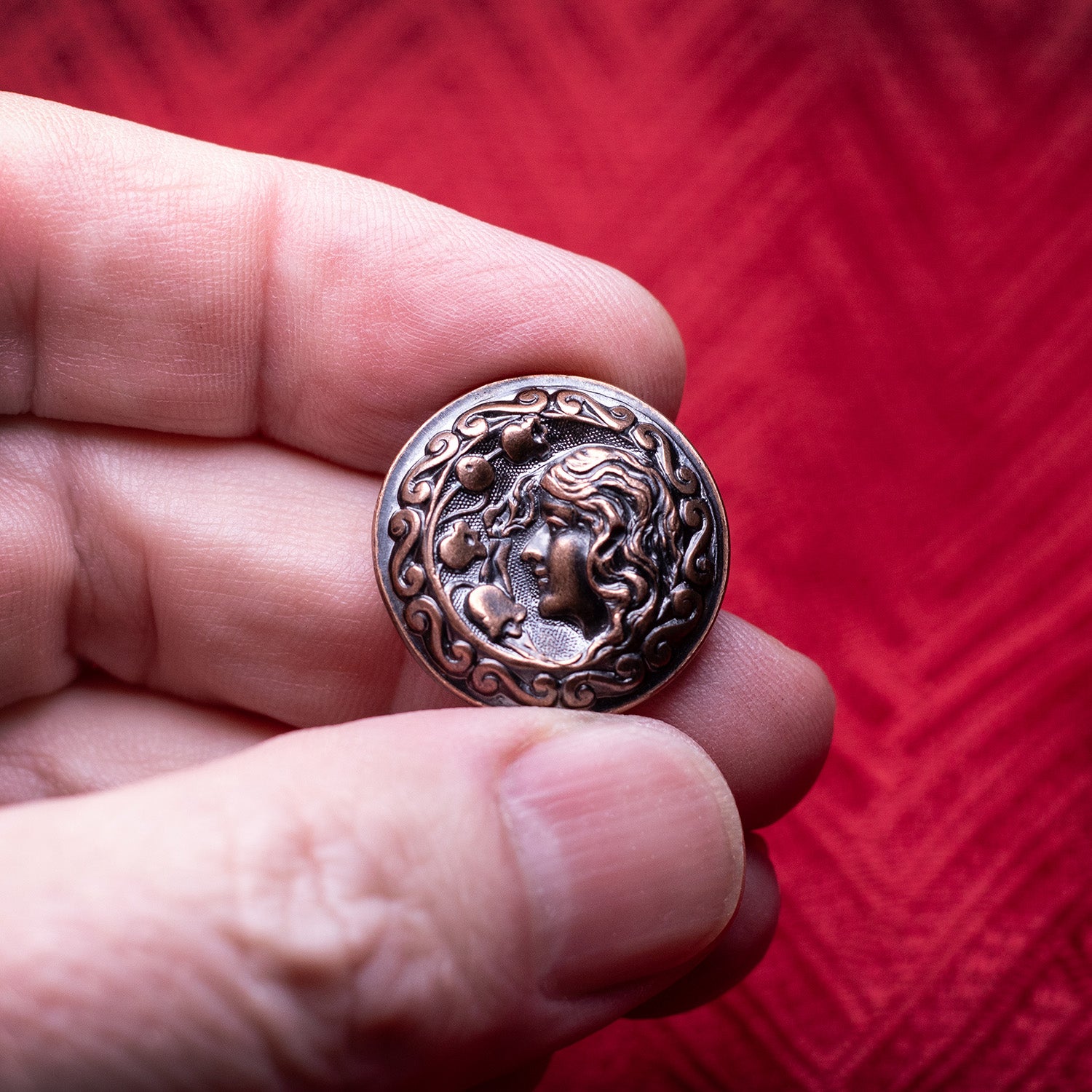 Thick copper worry coin featuring a woman's profile and vintage floral design