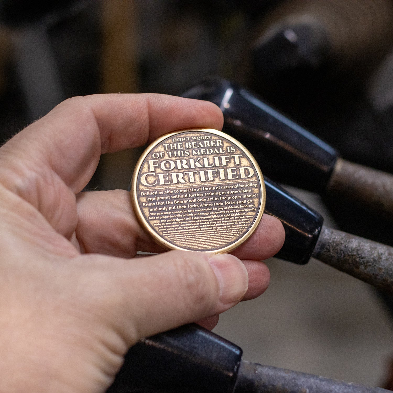 Hand holding brass Shire Post Mint Forklift Certified Coin