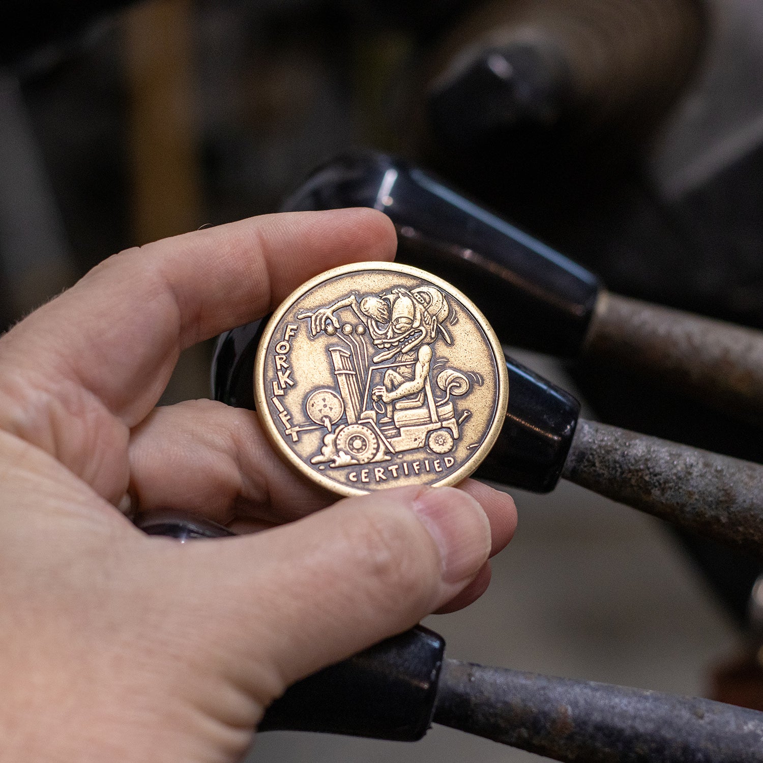 Hand holding brass Shire Post Mint Forklift Certified Coin 