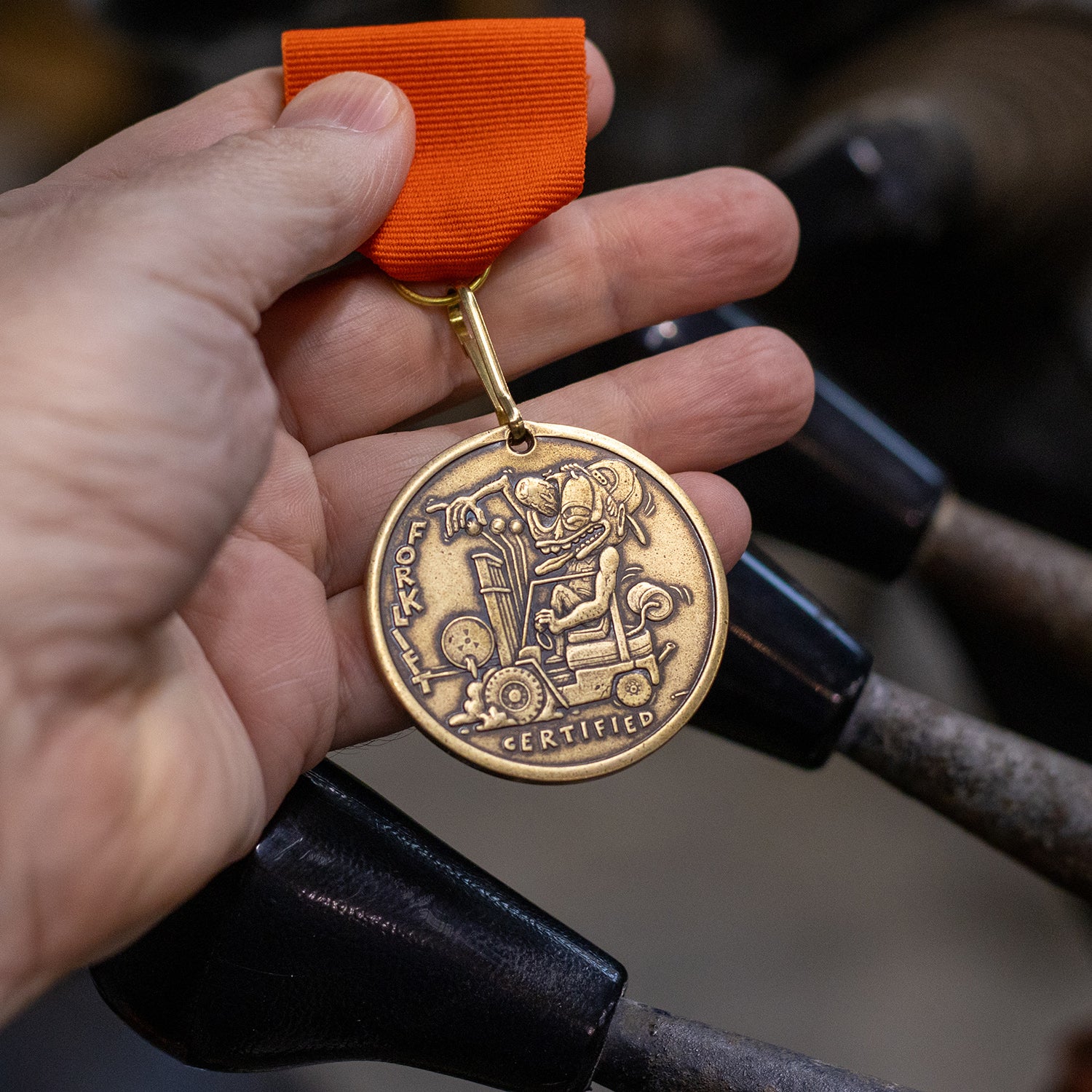 Hand holding brass Shire Post Mint Forklift Certified medal on pin back