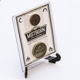 Molded plastic display stand shown displaying Mistborn coin set in 3"x4" toploader packaging 